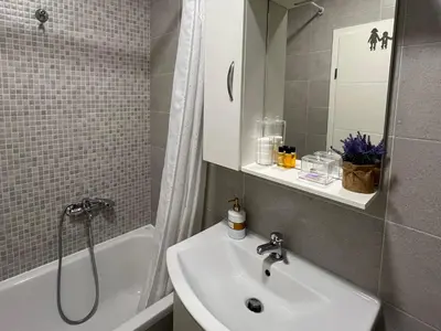 a bathroom with a sink and a shower and a tub at STENI Apartman in Doboj