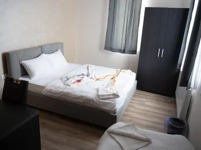 a bedroom with a bed with clothes on it at Motel Rezime in Zenica