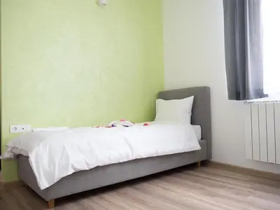 a bed in a room with a green wall at Motel Rezime in Zenica
