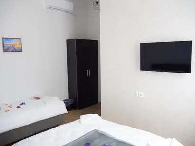 a room with two beds and a flat screen tv at Motel Rezime in Zenica
