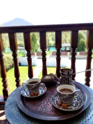 two cups of coffee on a table on a porch at Bosanska kuća Emina in Bihać