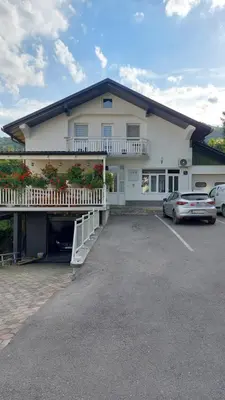 a building with a car parked in a parking lot at Apartman Eva in Jajce