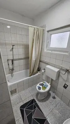 a bathroom with a toilet and a bath tub at Apartman Naza in Kulen Vakuf
