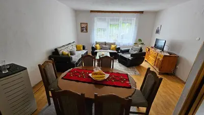 a living room with a table and a dining room at Apartman Naza in Kulen Vakuf
