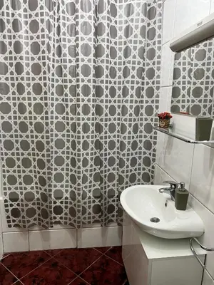 a bathroom with a shower curtain and a sink at Apartment Titanic 3 in Tuzla