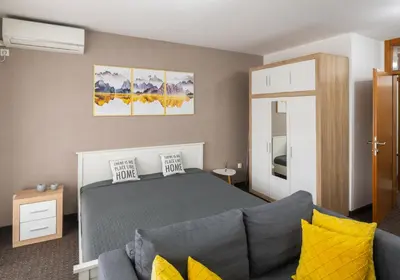 a bedroom with a bed and a couch at Apartment Titanic 3 in Tuzla