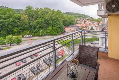 a balcony with a chair and a view of a city at Apartment Titanic 3 in Tuzla