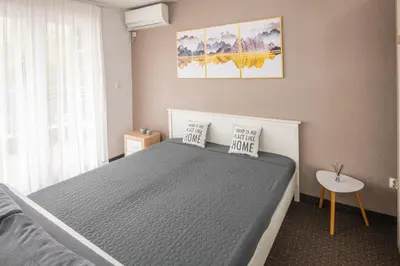 a bedroom with a large bed and a table at Apartment Titanic 3 in Tuzla