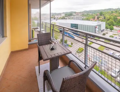 a table and chairs on a balcony with a view at Apartment Titanic 3 in Tuzla
