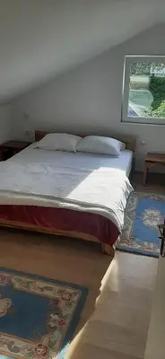 a bedroom with a bed and a large window at Apartman Vrbas in Jajce