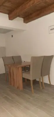 a dining room with a wooden table and chairs at Apartman Vrbas in Jajce