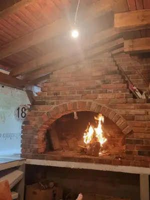 a brick oven with a fire in it at Vikendica za odmor in Busovača
