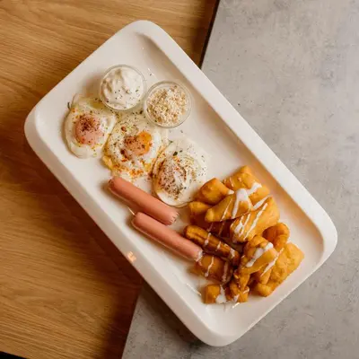 a white tray with eggs and other food on a table at CIOM Apartment in Matuzići