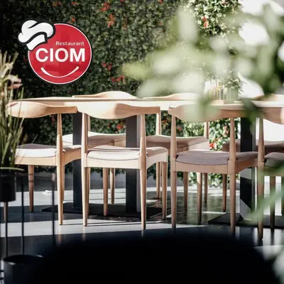 a wooden table and chairs with a sign on it at CIOM Apartment in Matuzići
