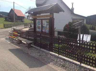 a building with a bench next to a fence at Apartments Baba Luce in Strica