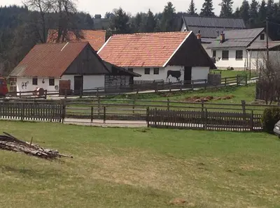 a farm with a fence and two white buildings at Apartments Baba Luce in Strica
