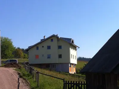 a house on the side of a road next to a fence at Apartments Baba Luce in Strica