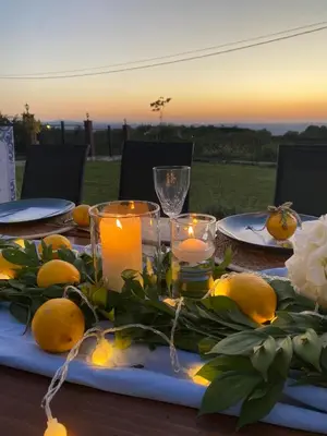 a table with candles and lemons on it with the sunset at Vikendica Krcmarice- Banja Luka in Banja Luka