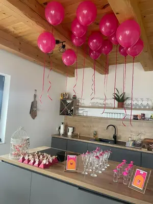 a table with pink balloons hanging from a ceiling at Vikendica Krcmarice- Banja Luka in Banja Luka