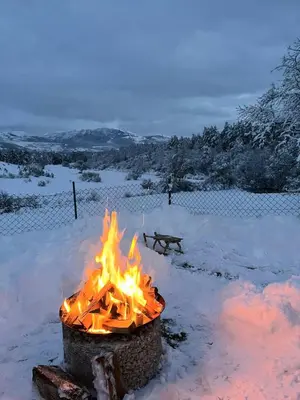 a fire pit with flames in the snow at Apartman Stupe in Livno
