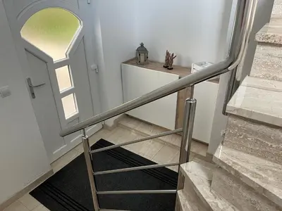 a staircase with a metal handrail next to a door at Apartman Stupe in Livno