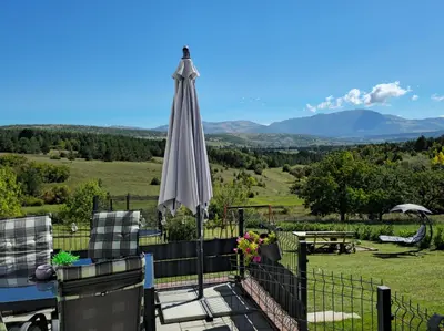 a patio with an umbrella and a table and chairs at Apartman Stupe in Livno
