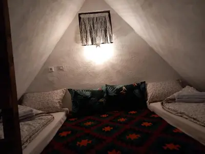 a attic room with two beds and a rug at Kuća za odmor-Vikendica- in Visoko