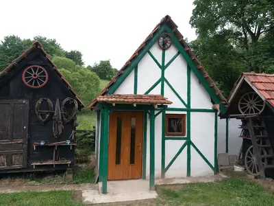 a small white and green house with a wheel at Kuća za odmor-Vikendica- in Visoko