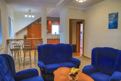 a living room with blue chairs and a table at APARTMAN NAAJ in Bihać