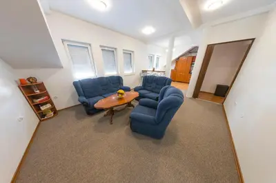 a living room with two blue chairs and a table at APARTMAN NAAJ in Bihać