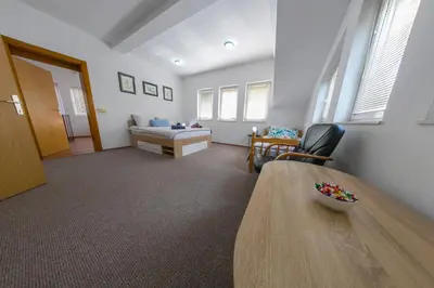 a room with a bed and a table and a chair at APARTMAN NAAJ in Bihać