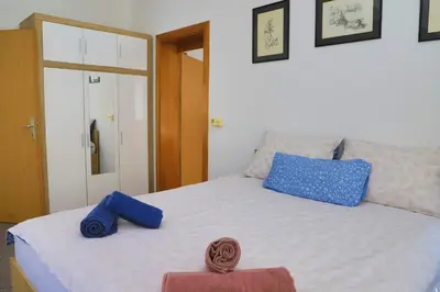 a bed with two blue pillows on top of it at APARTMAN NAAJ in Bihać