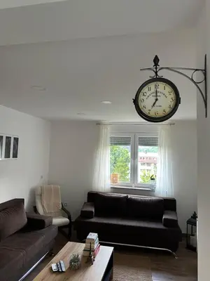 a living room with a couch and a clock hanging from the ceiling at Sara in Jajce
