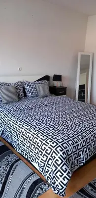 a bed with a black and white comforter in a bedroom at Ferienwohnung Sabina in Bosanska Krupa