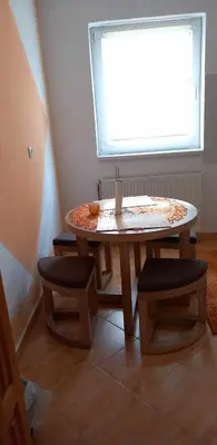 a table and two stools in a room with a window at Ferienwohnung Sabina in Bosanska Krupa
