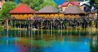 a building on a bridge over a body of water at Ferienwohnung Sabina in Bosanska Krupa