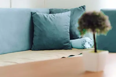 a blue couch with a pillow and a plant on a table at Weekend Joy Home in Visoko