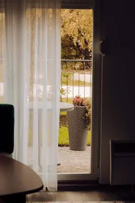 an open door to a patio with a pot of flowers at Weekend Joy Home in Visoko