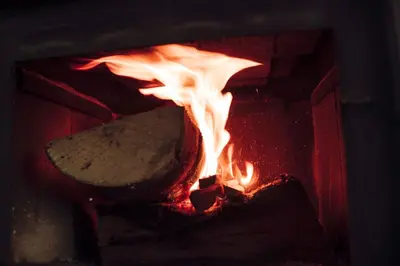 a fire in a brick oven with a spatula at Weekend Joy Home in Visoko