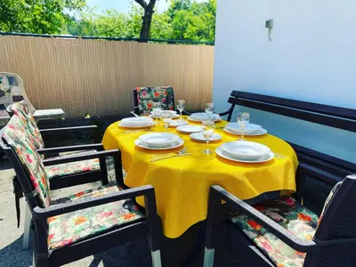 a yellow table with plates and wine glasses on it at Weekend Joy Home in Visoko