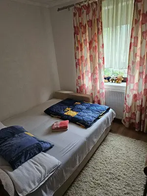a bedroom with a bed and a window with curtains at Apartman Slapovi in Krupa na Vrbasu