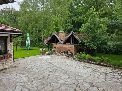 a brick house with a brick driveway in front of a yard at Apartman Slapovi in Krupa na Vrbasu