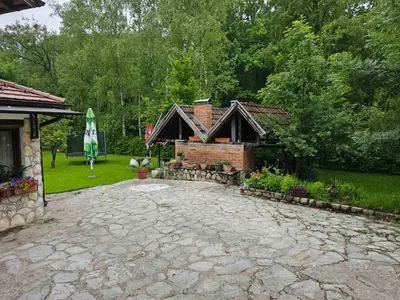 a house with a brick driveway in a yard at Apartman Slapovi in Krupa na Vrbasu