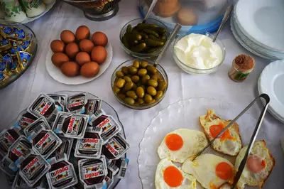a table topped with plates of breakfast food and eggs at Pansion Kipovi in Tuzla