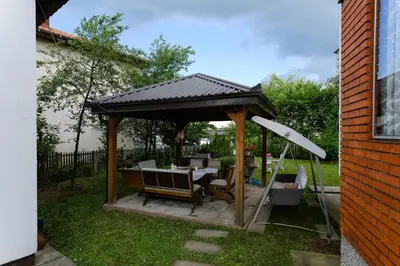 a wooden gazebo with a table in a yard at The Cosmic Gate 3 in Biskupići