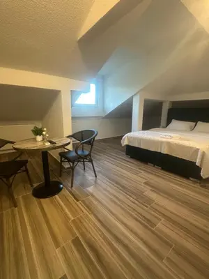 a bedroom with a bed and a table and a desk at Hotel Piramida Sunca in Visoko