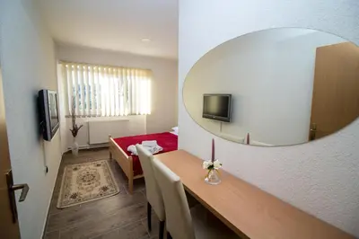 a room with a mirror and a table with a red couch at Hotel Piramida Sunca in Visoko