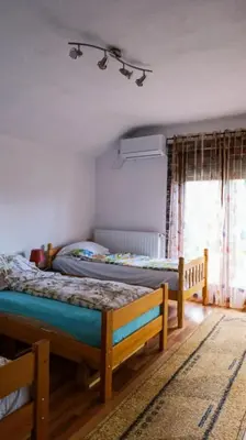 a bedroom with two beds and a window at Kuća za odmor V&E in Bihać