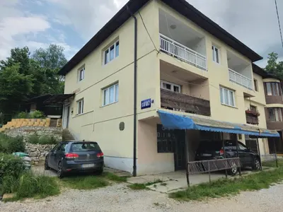 a house with two cars parked in front of it at Rooms Mery in Visoko