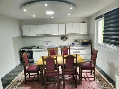a kitchen with a table with chairs and a stove at Rooms Mery in Visoko